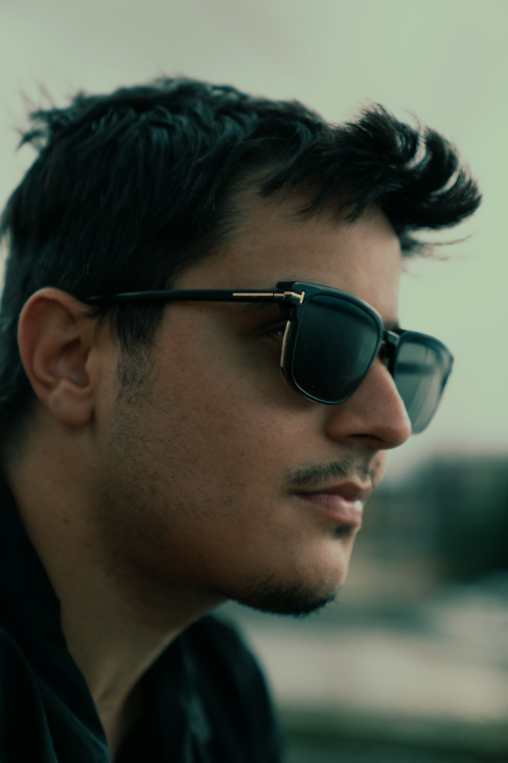 a man with black hair and sunglasses on