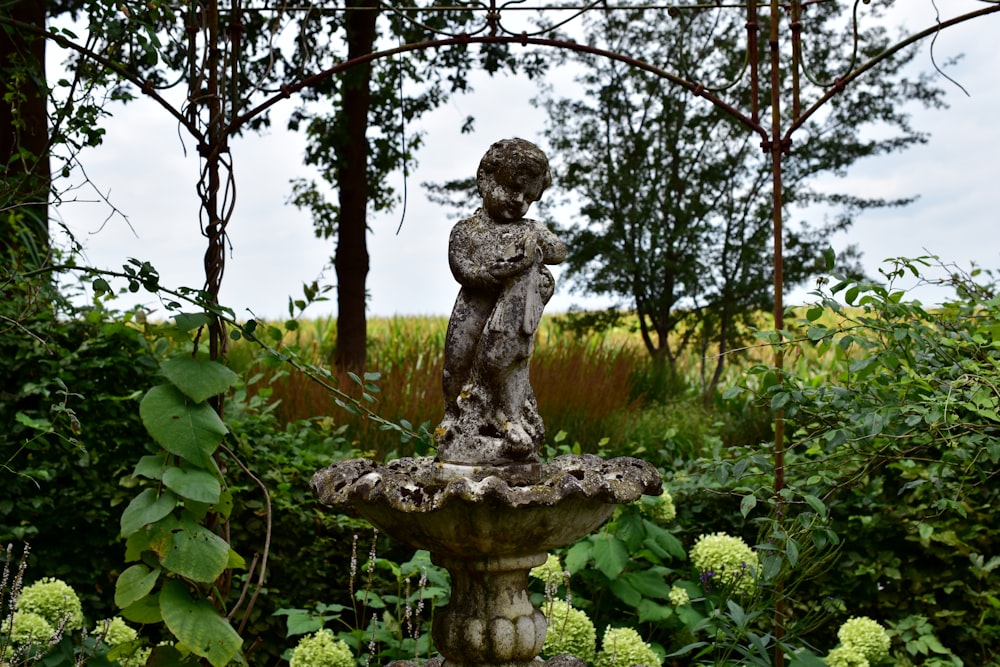 une statue d’une personne assise au sommet d’une fontaine