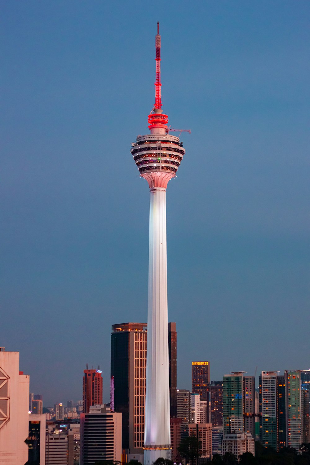 a tall tower with a red top in the middle of a city