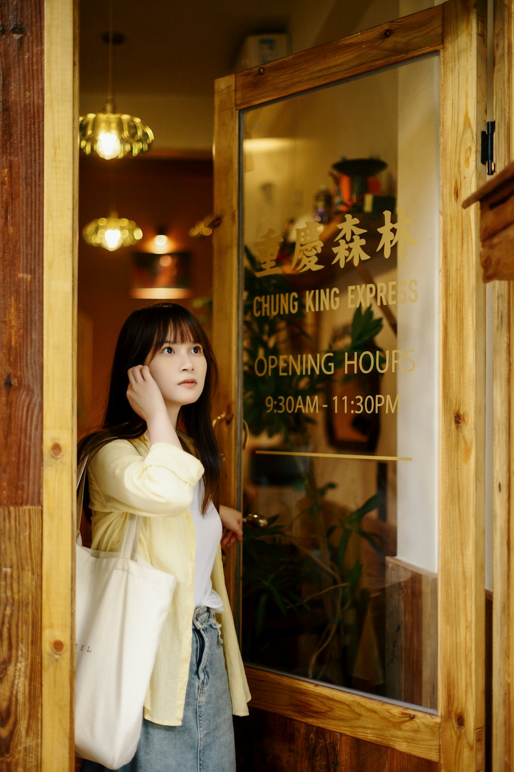 a woman standing in a doorway talking on a cell phone