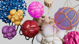 An abstract composition featuring various spherical and amorphous shapes, some encapsulated in metallic wireframes. These shapes are in vibrant hues like pink, purple, yellow, and red, and are set against a neutral background. The designs evoke a sense of flowing motion and artistic creativity.