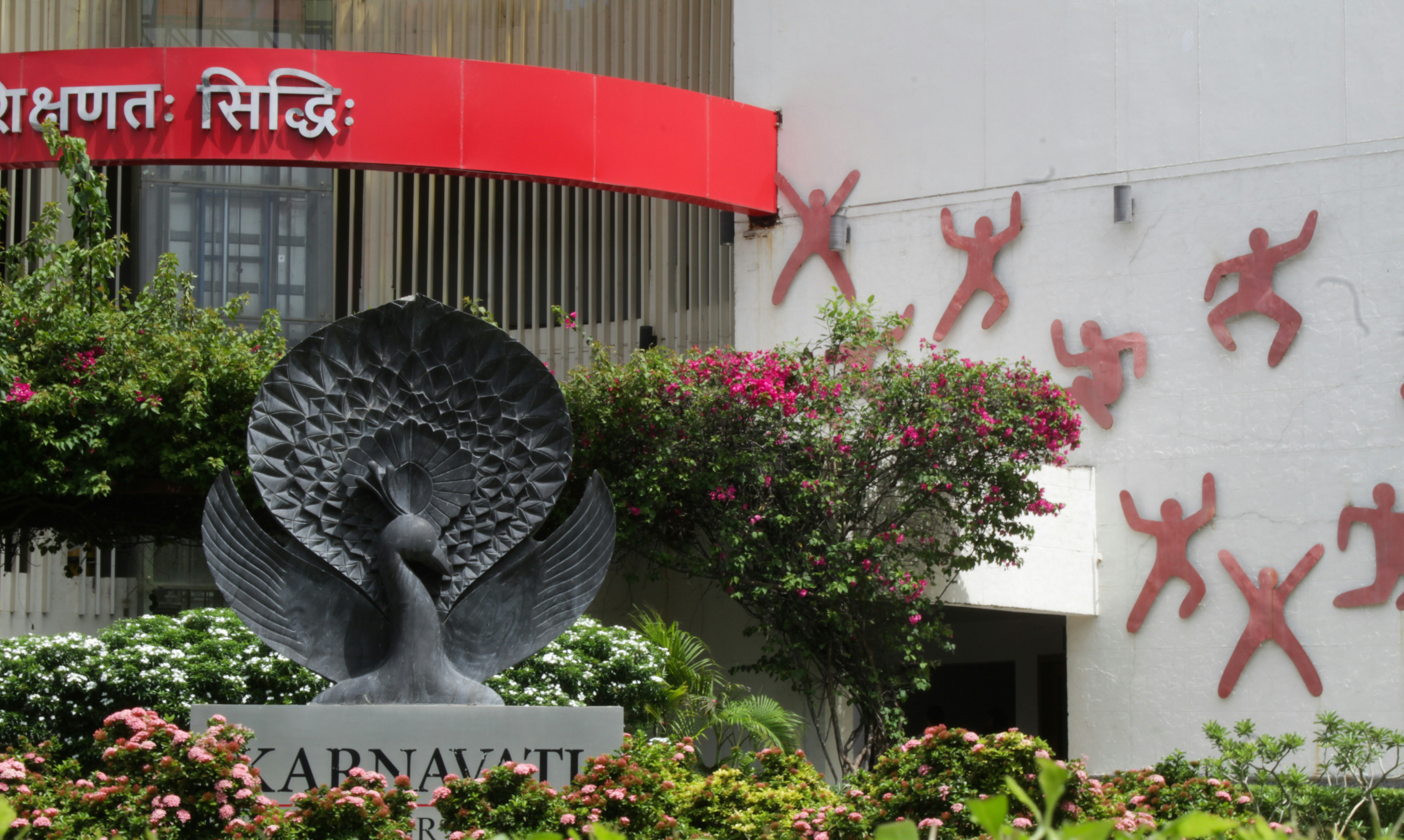 a statue of a peacock in front of a building
