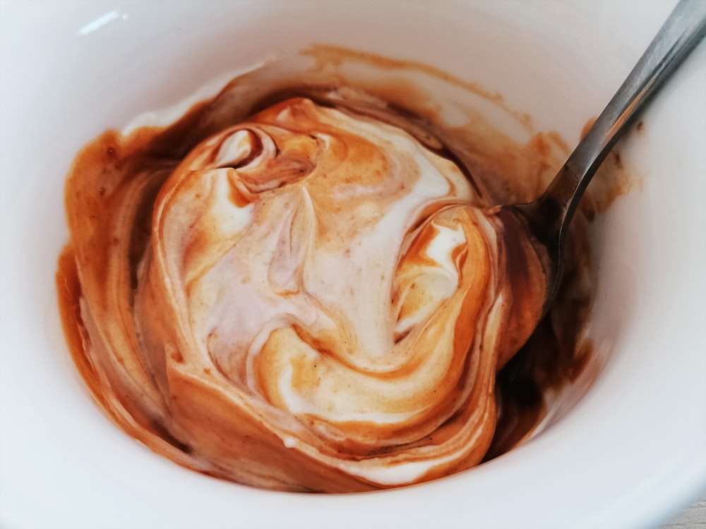 a white bowl with a spoon in it