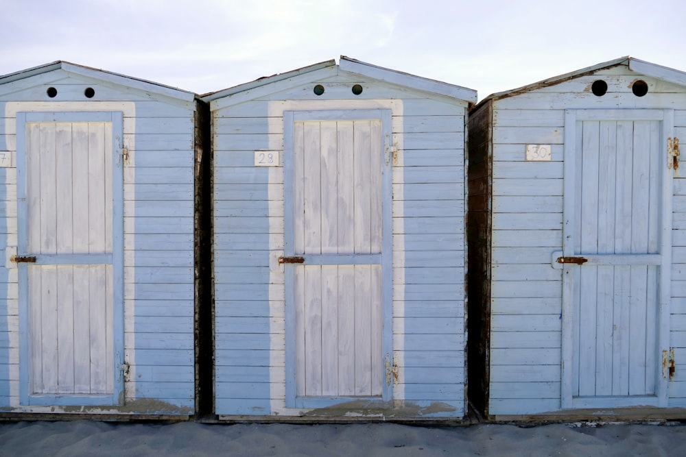 a row of white beach huts sitting next to each other