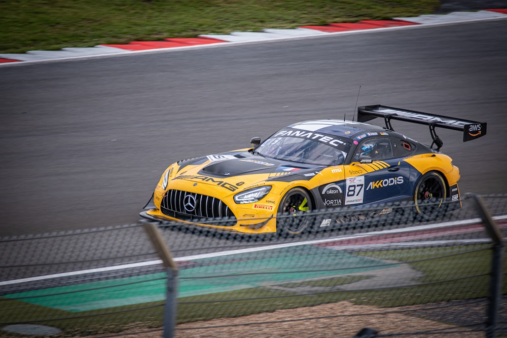 a yellow sports car driving on a race track