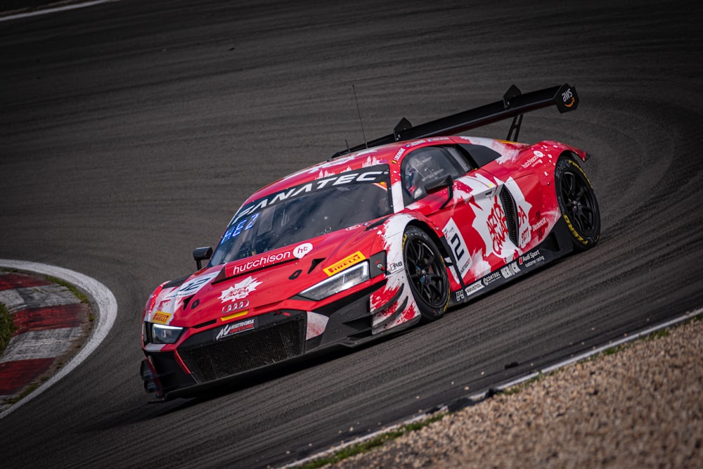 a red race car driving on a race track