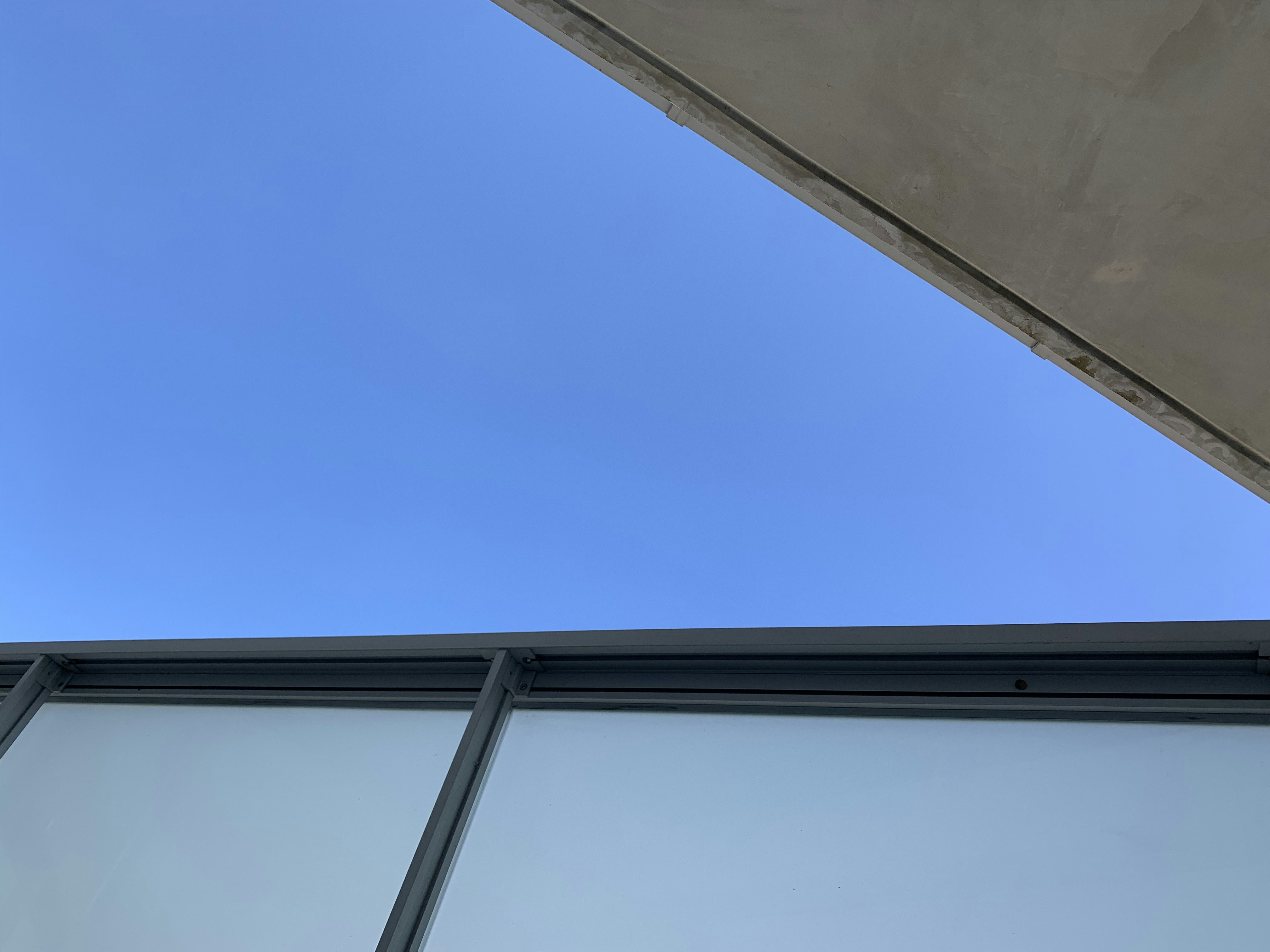 Modern commercial airport terminal building exterior with clear blue sky