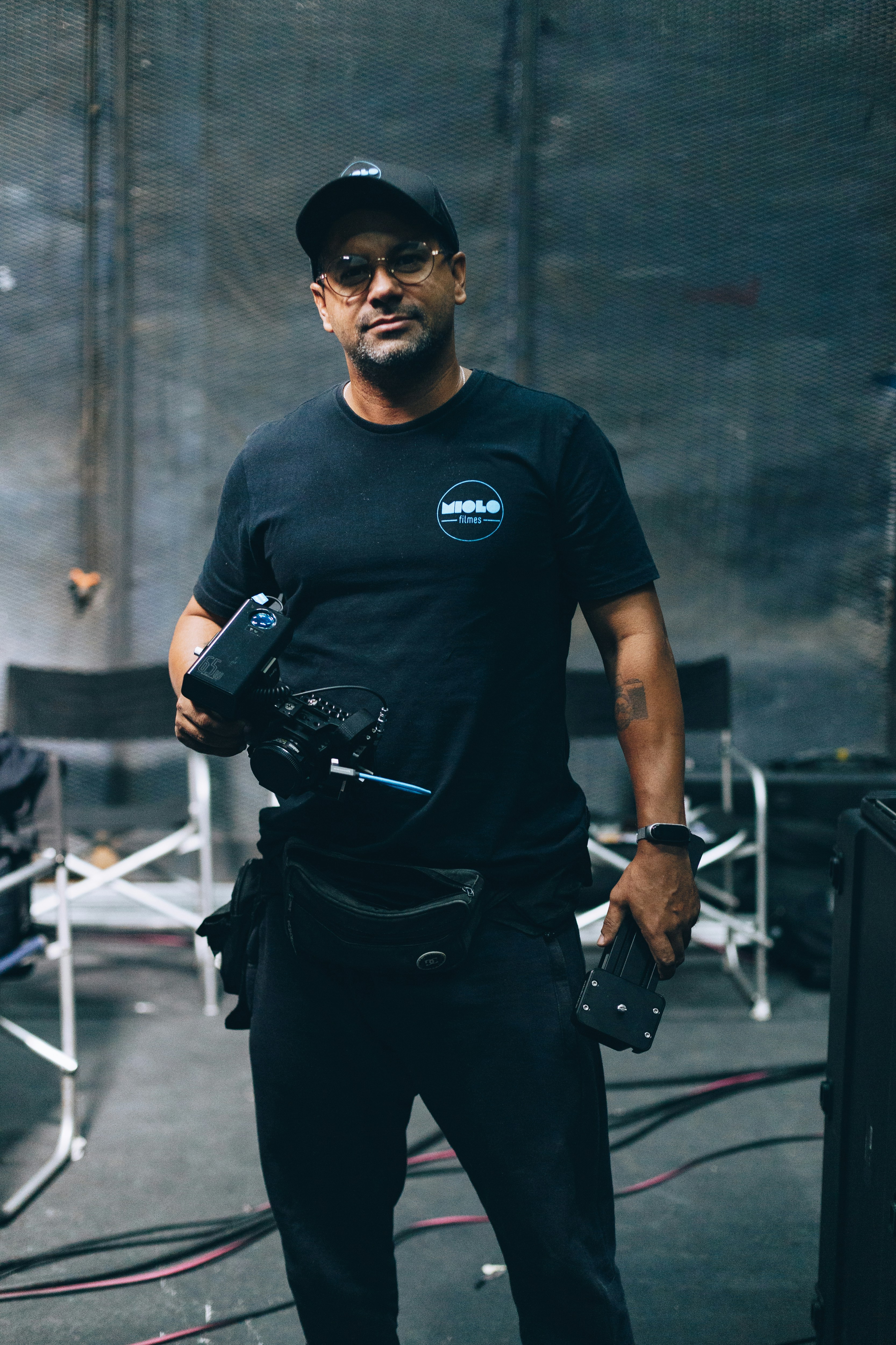 um homem de camisa preta segurando uma câmera