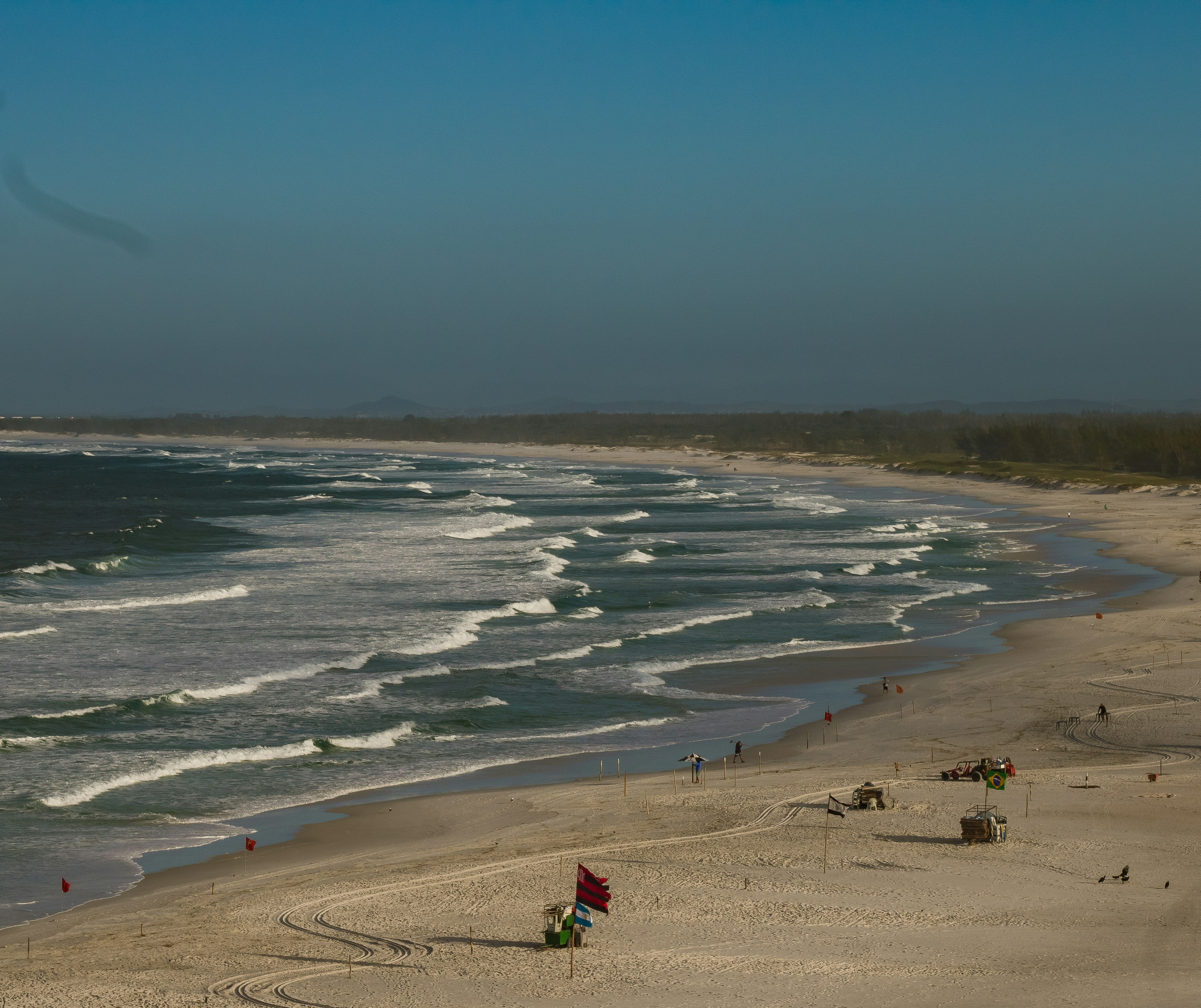 a view of a beach with people walking on it