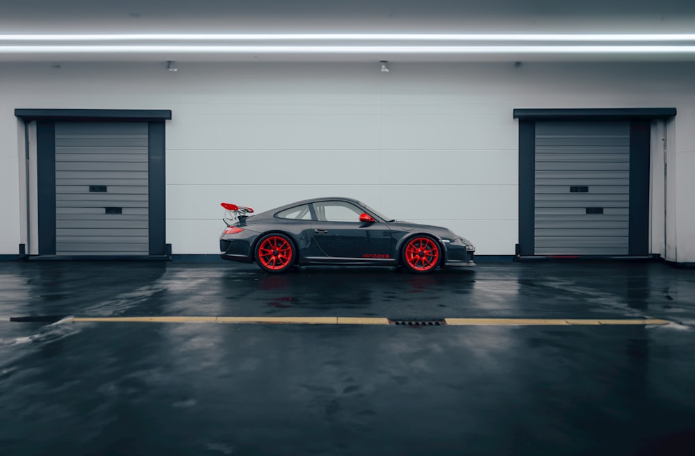 a car parked in a garage with red rims