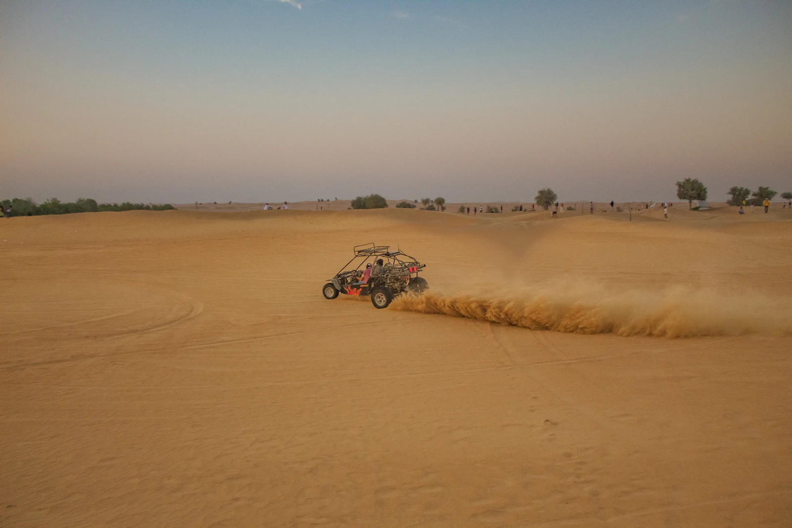 Dune buggy kicking up sand in the Abu Dhabi desert at dusk