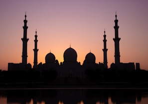The front view of Masjid Al Hujrah during sunset showing its elegant architecture