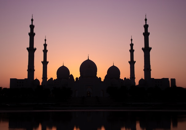 A serene view of the holy mosque during sunset, highlighting its architectural beauty.