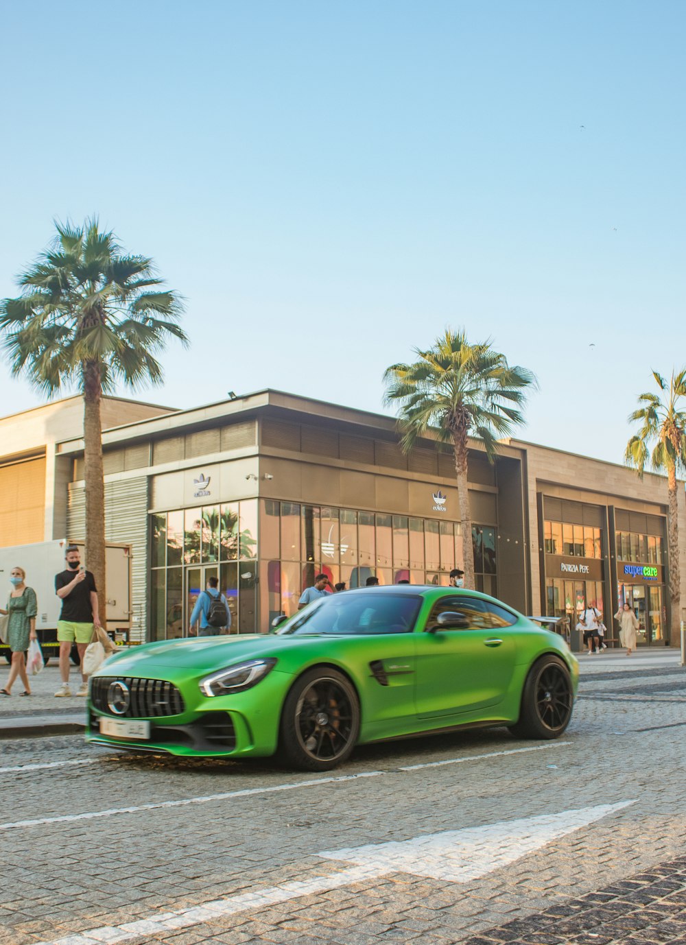 a green sports car parked in front of a building