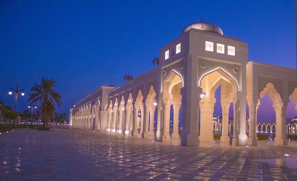 a white building with arches and pillars lit up at night