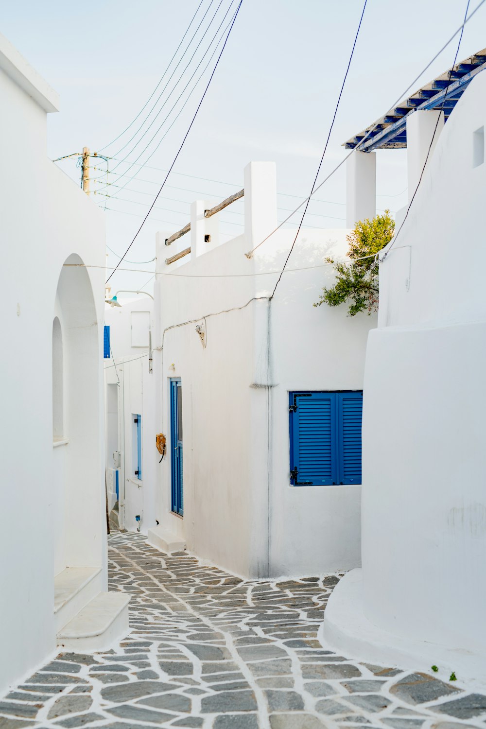 a cobblestone street with blue doors and shutters