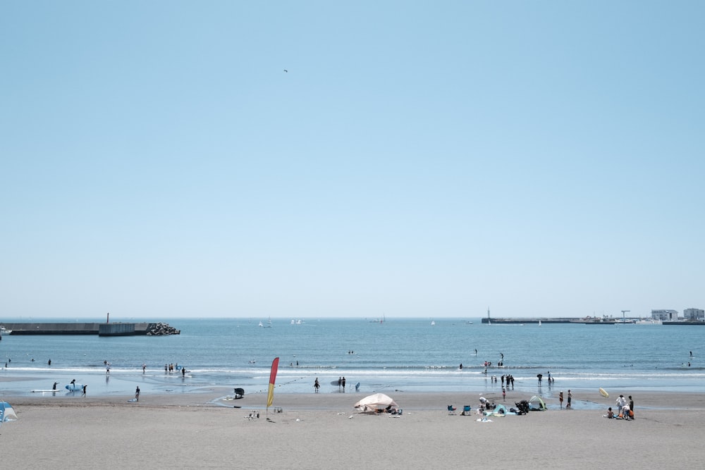 a group of people standing on top of a sandy beach