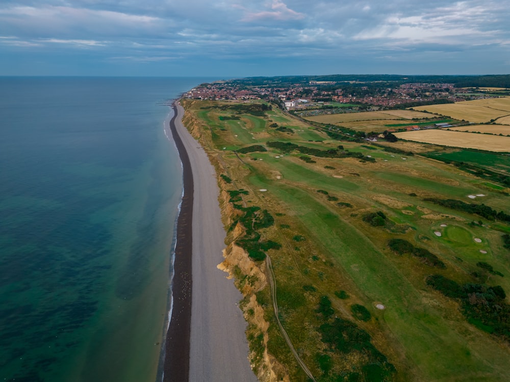 an aerial view of a golf course next to the ocean