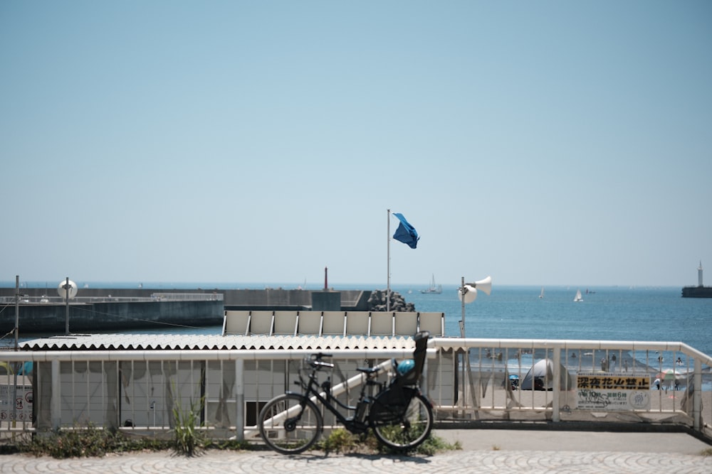 una bici parcheggiata sul ciglio di una strada vicino all'oceano