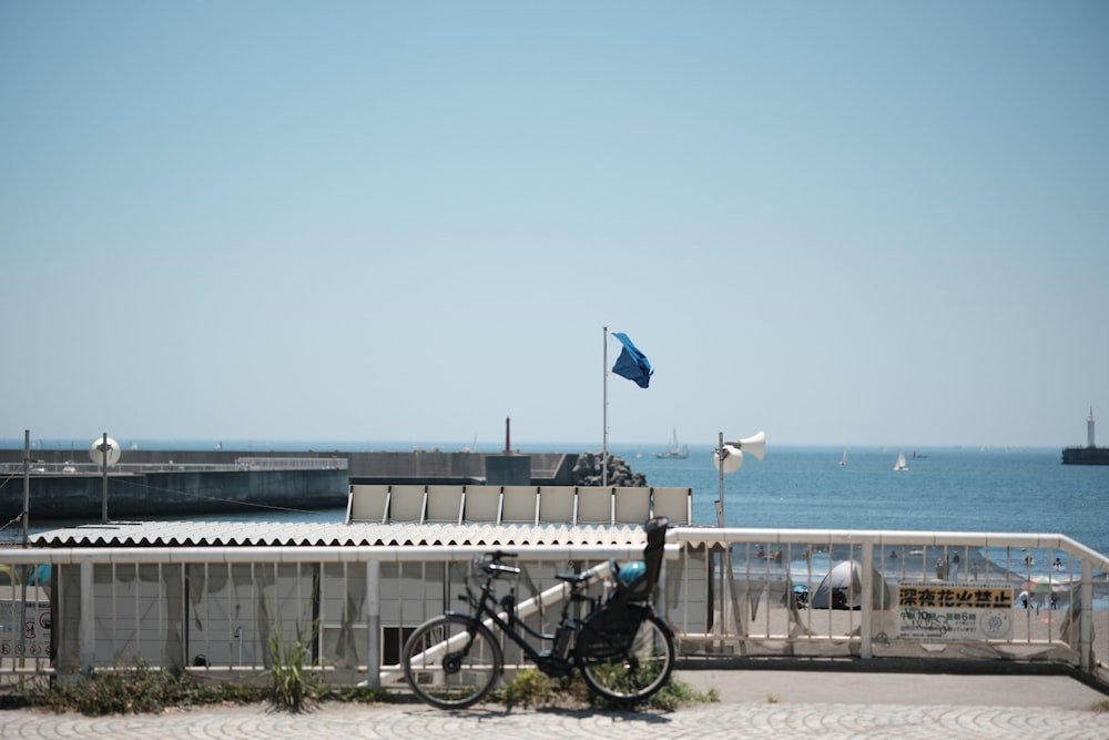 a bike parked on the side of a road next to the ocean