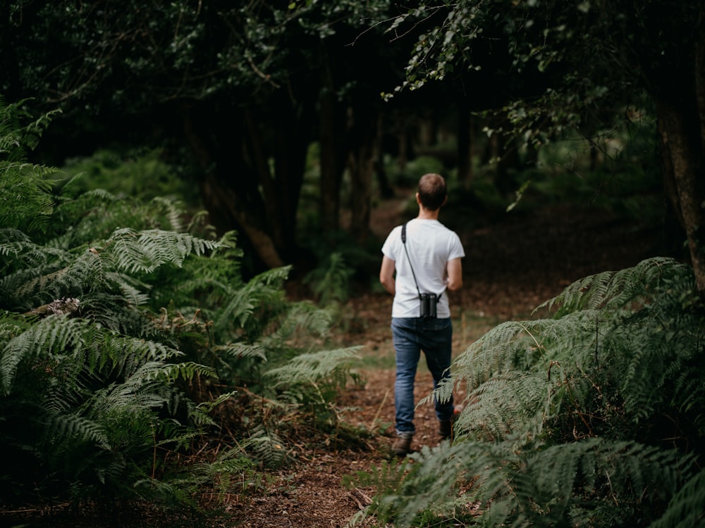 a man with a backpack walking through a forest