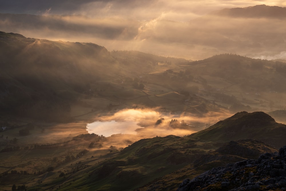 the sun is shining through the clouds over the mountains