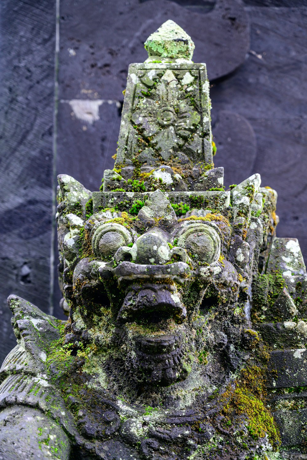 a stone statue with moss growing on it