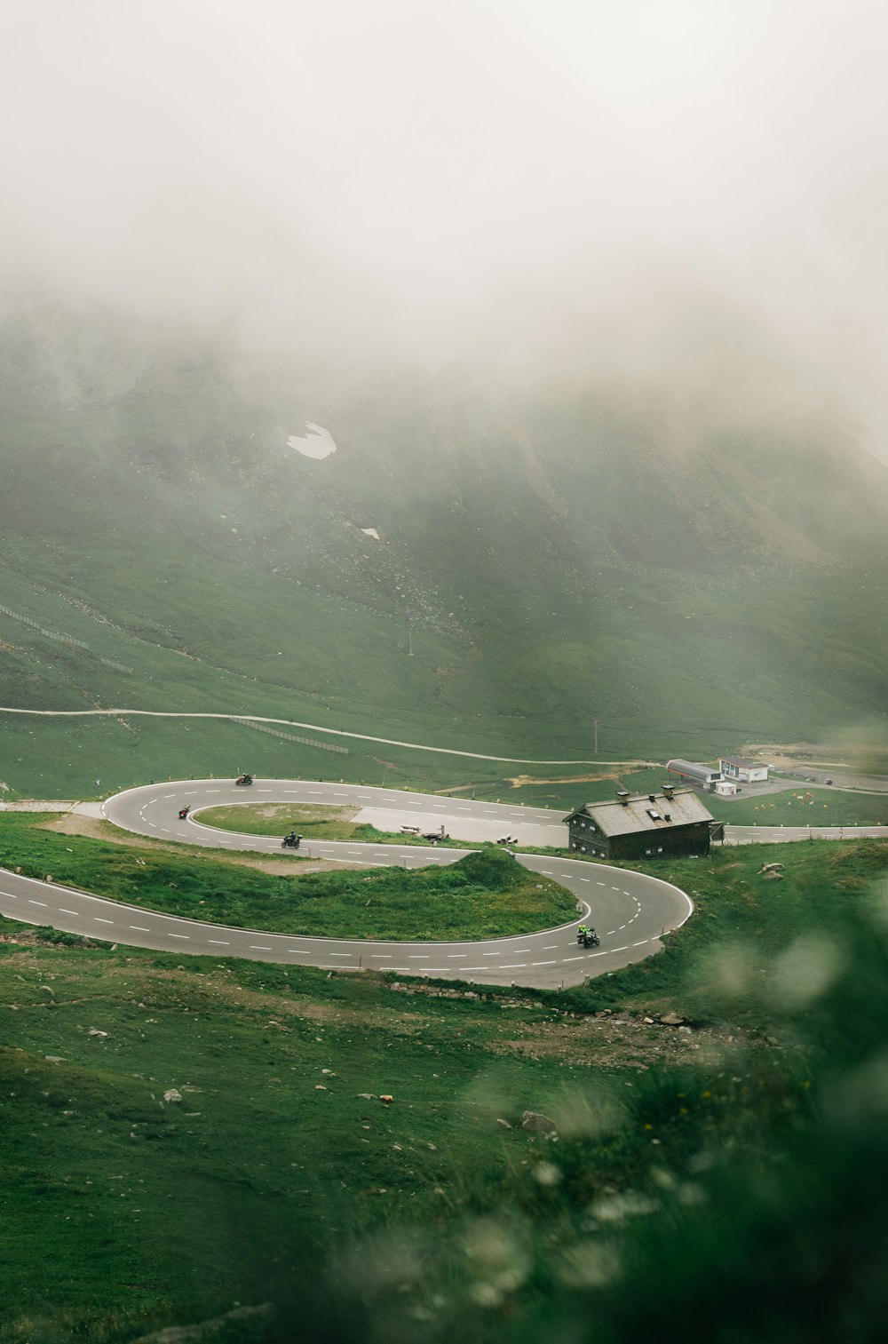 a winding road in the middle of a lush green valley