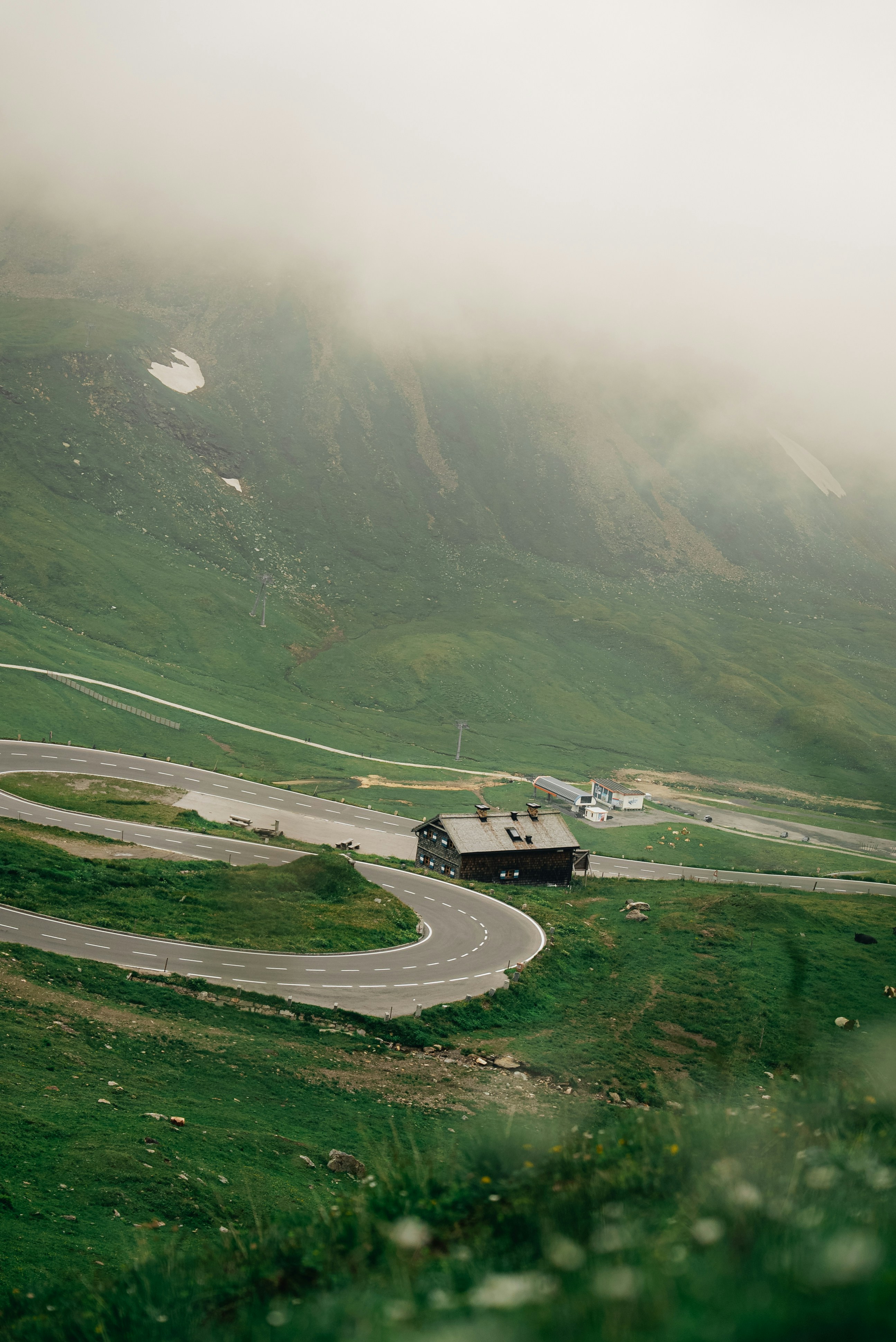 a winding road in the middle of a green mountain