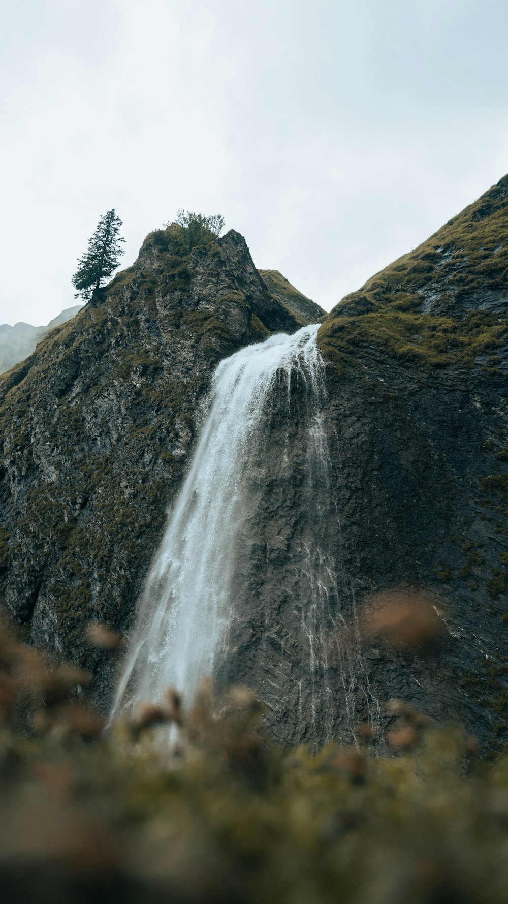 Una piccola cascata che scende a cascata lungo un fianco della montagna