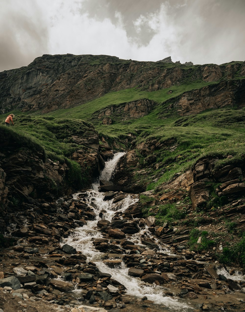 a stream running through a lush green hillside