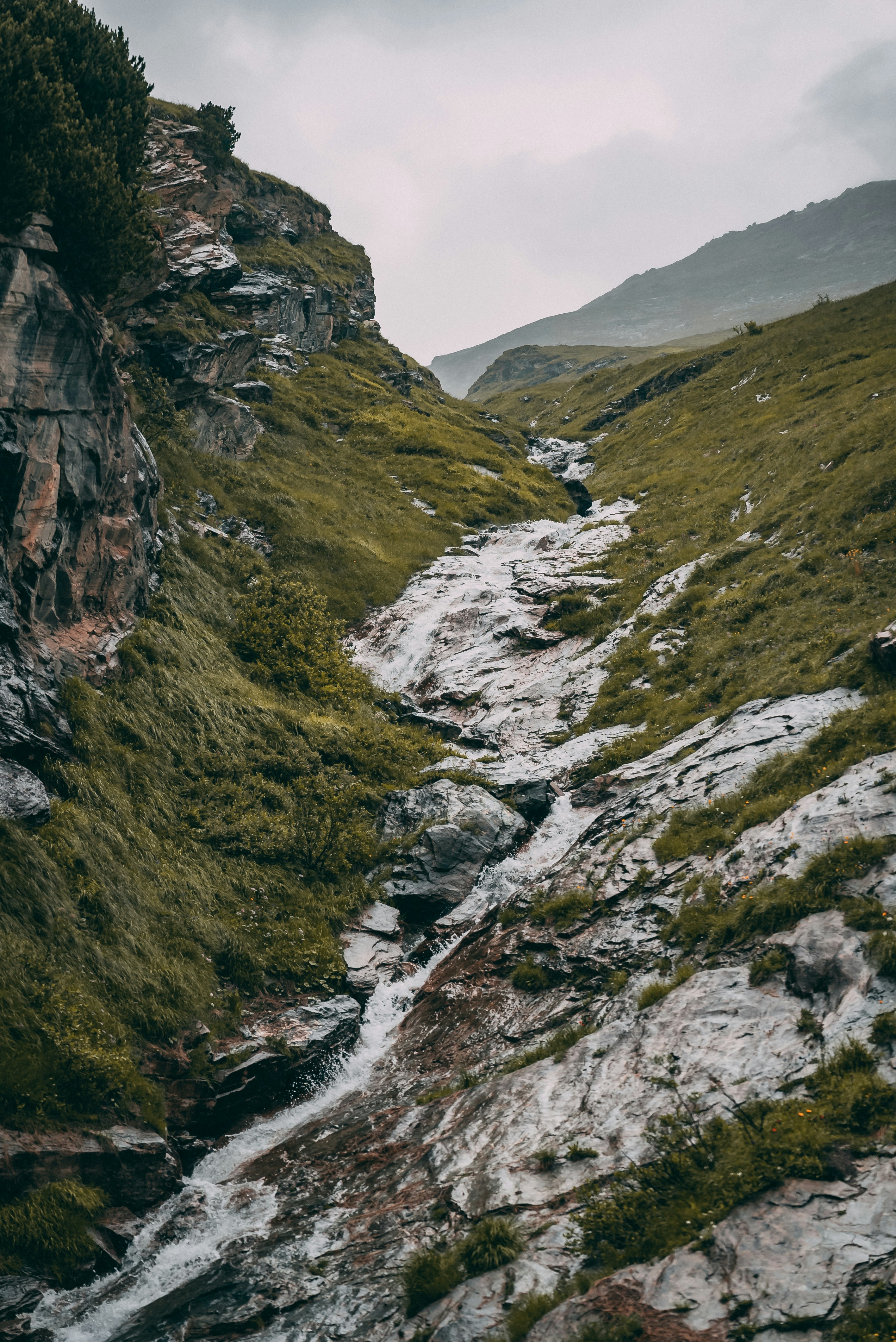 a rocky mountain with a stream running through it