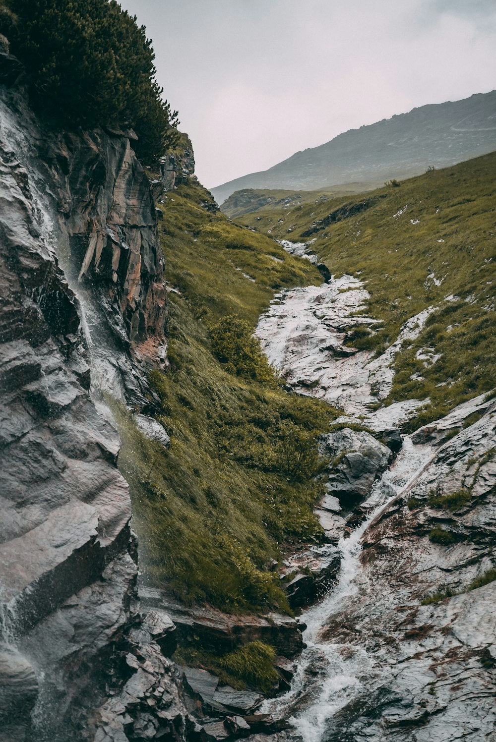 a rocky mountain with a stream running between it