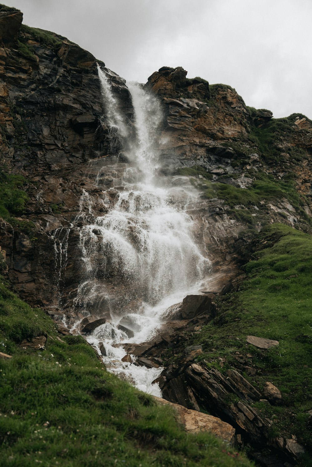 una cascata molto alta nel mezzo di un rigoglioso campo verde