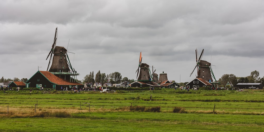 a group of windmills sitting on top of a lush green field