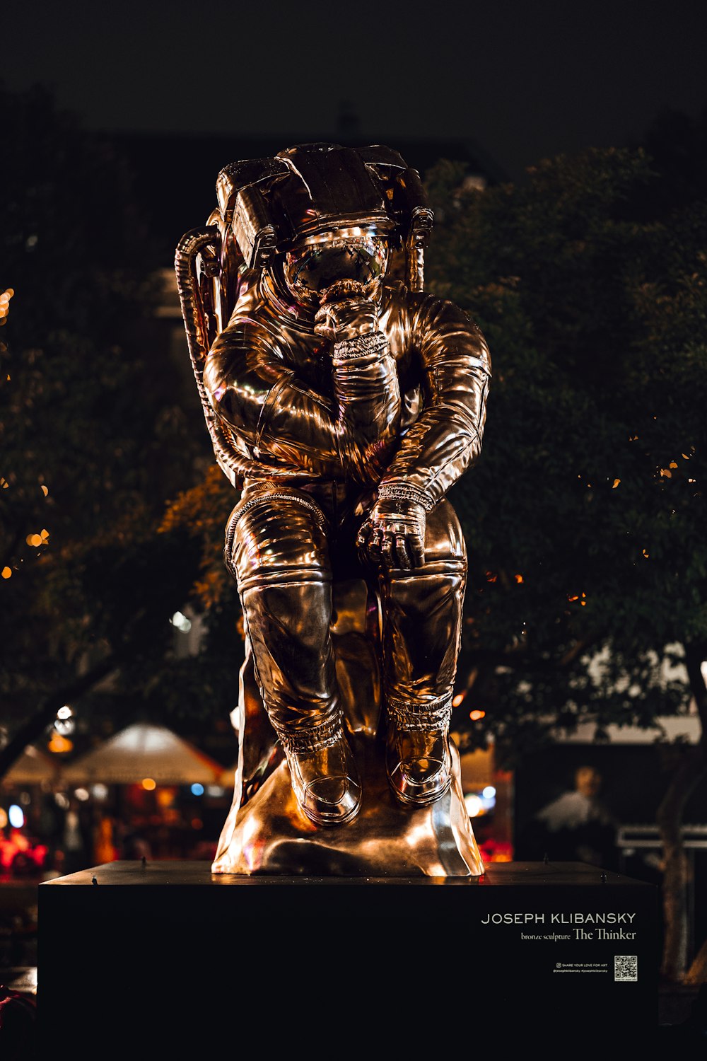 a statue of a man sitting on top of a bench