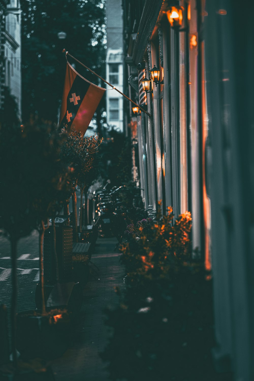 a city street at night with a flag on a pole