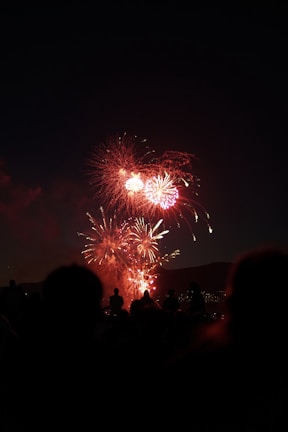 A vibrant crowd cheering with $happy banners under colorful fireworks
