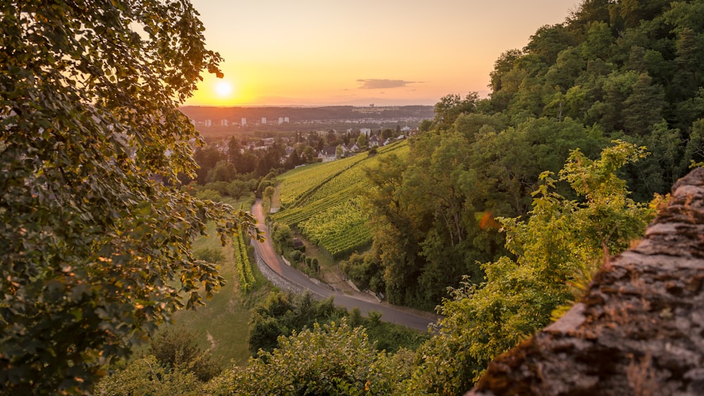 the sun is setting over a winding road