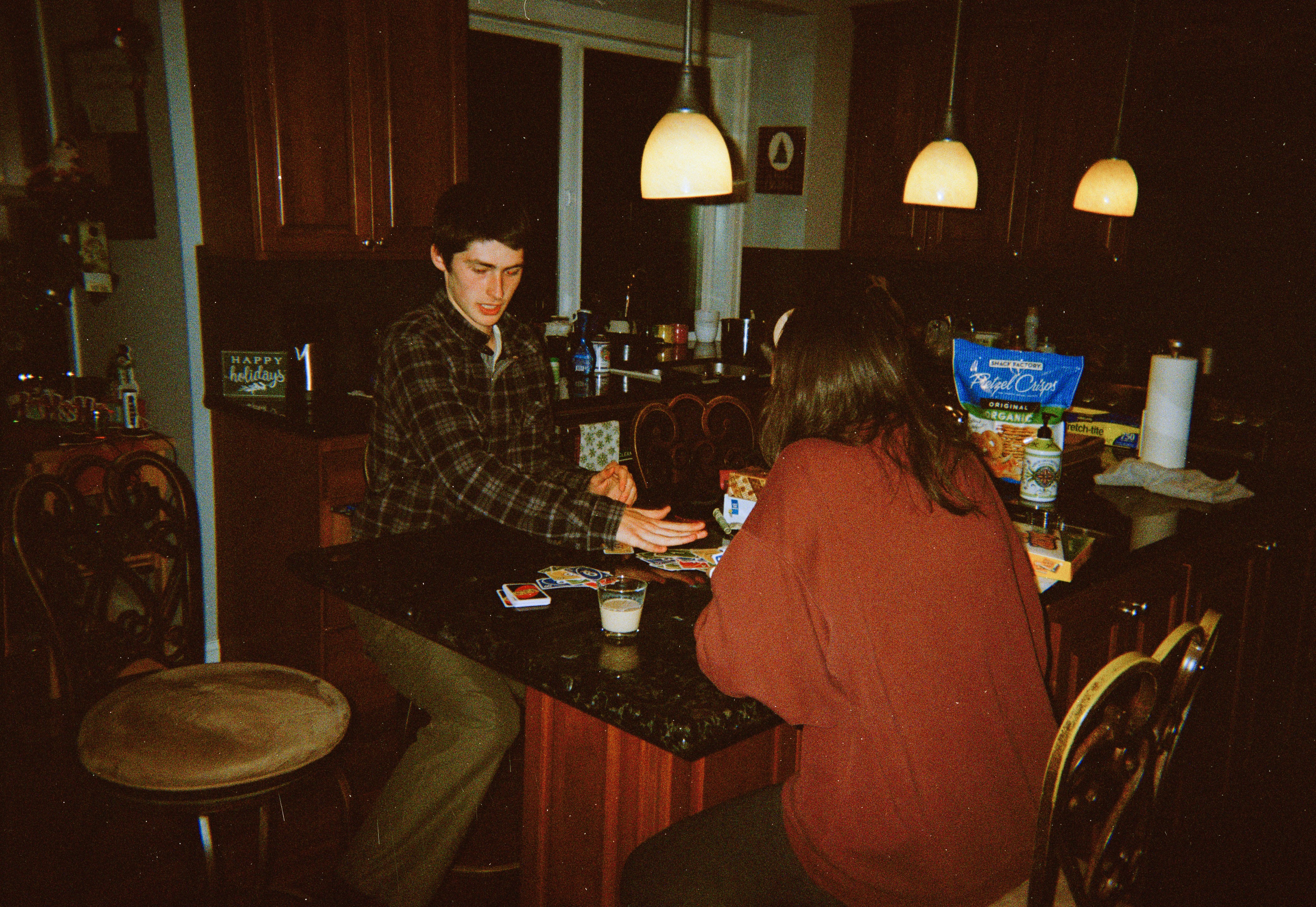 Parent at a kitchen table in the evening entering school dates from letters into a calendar on a laptop