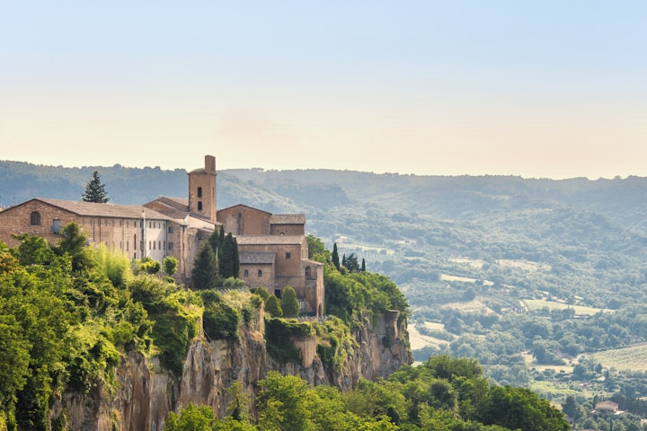 Orvieto Cathedral and medieval buildings atop volcanic cliffs in Italy.