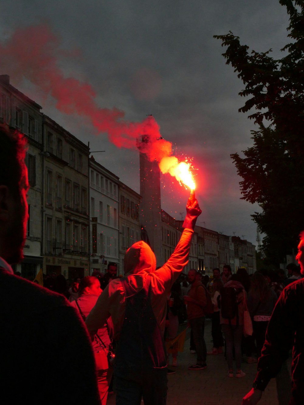 a group of people standing on a street holding flarers