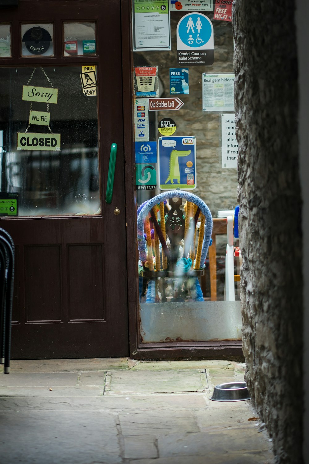 a store front with a door that has a bunch of signs on it