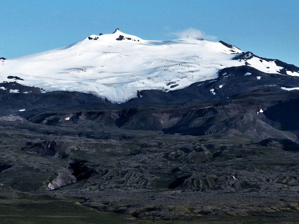 uma montanha coberta de neve com um fundo de céu