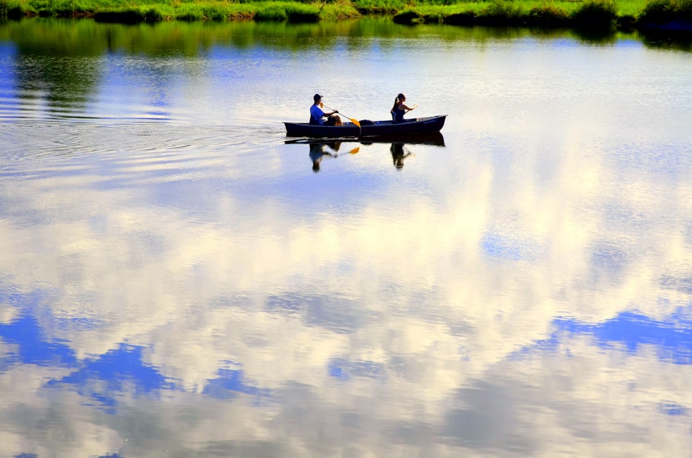 two people in a small boat on a lake