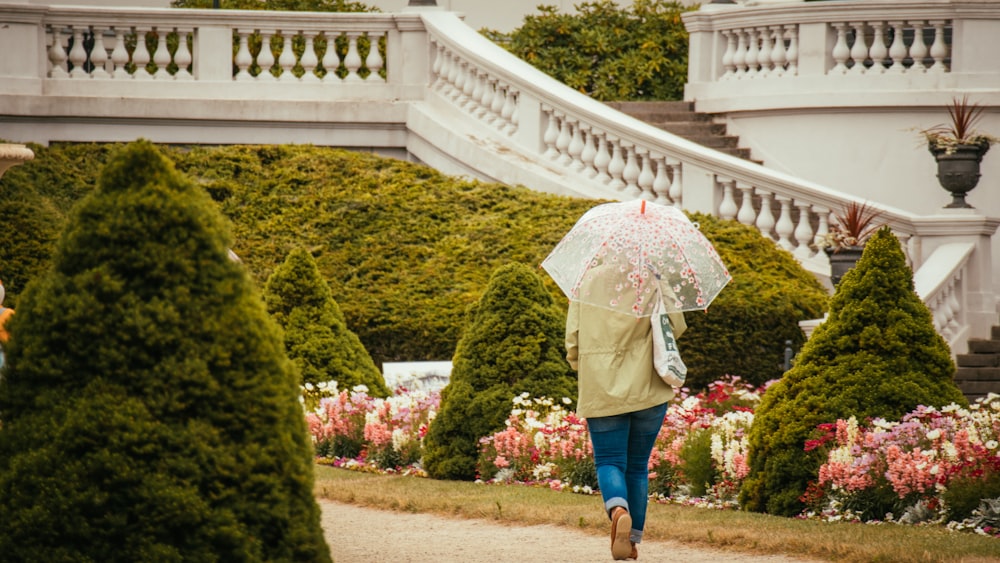 a woman walking down a path holding an umbrella