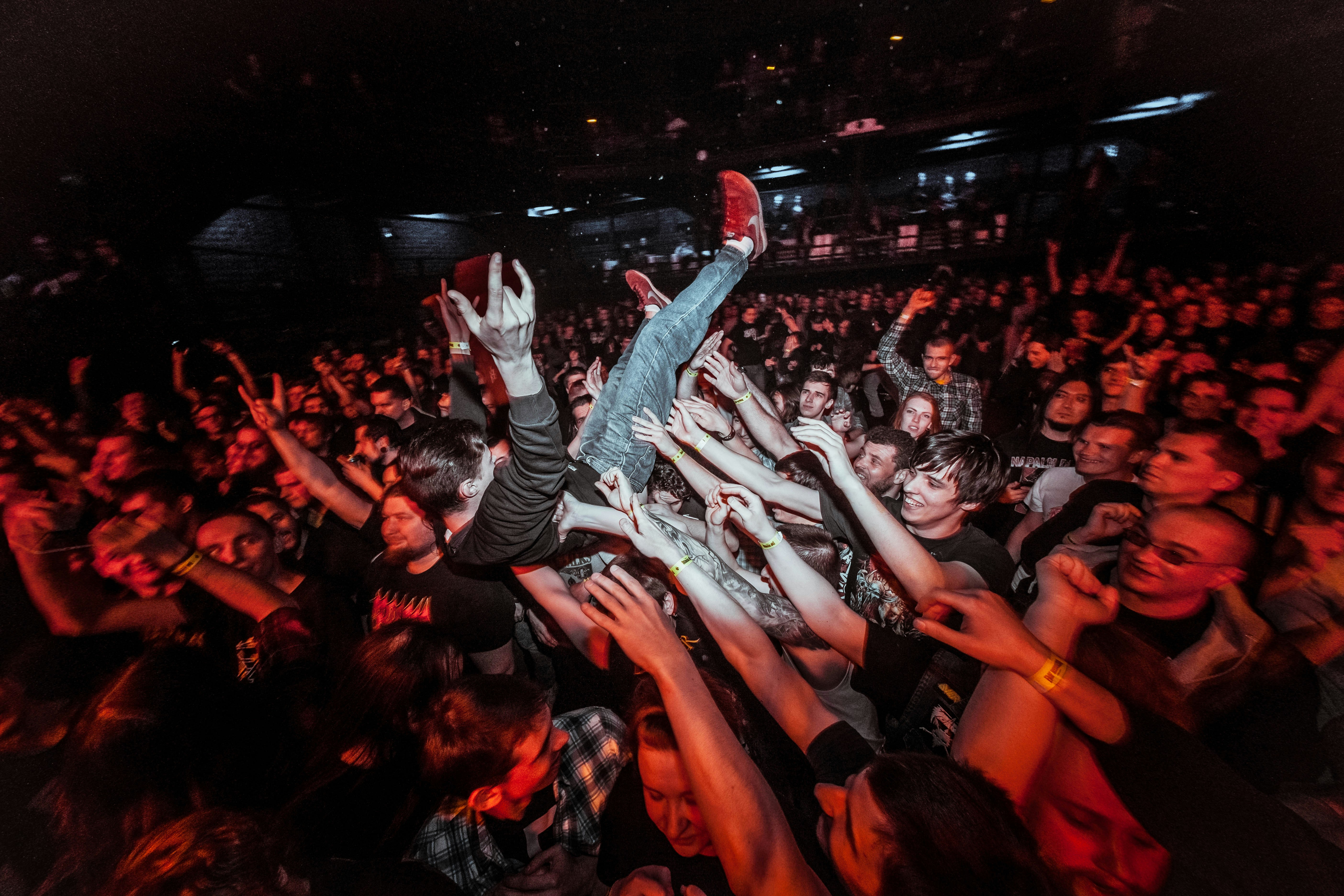 a crowd of people at a concert with their hands in the air