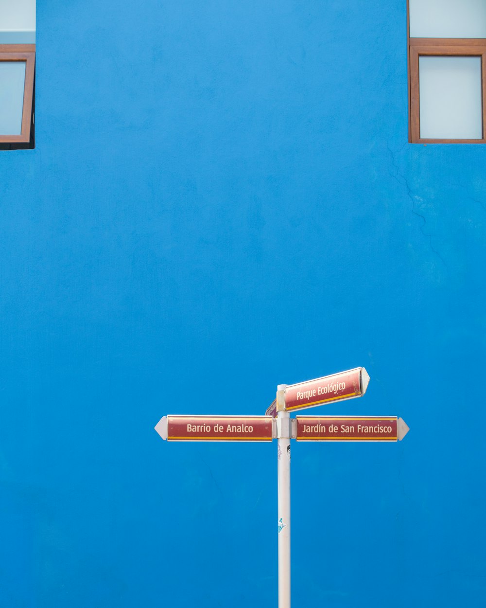 a street sign in front of a blue wall