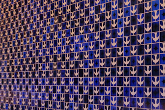 a blue and white tiled wall with white arrows