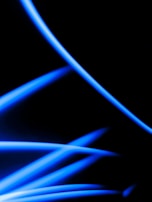 Abstract orbital lines and shapes softly glowing in neon blue against a deep black gradient.